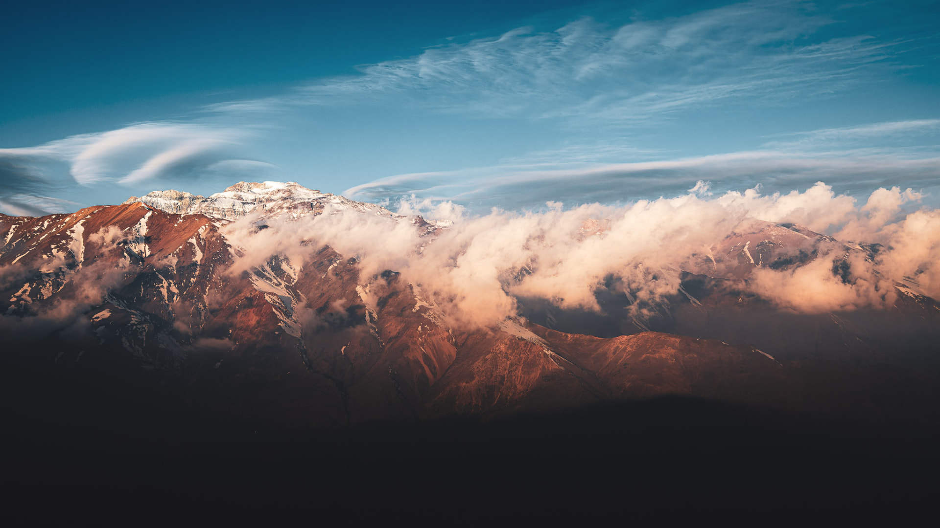 Cordón Sierra San Francisco cubierto por nubes con el Cerro El Plomo al fondo