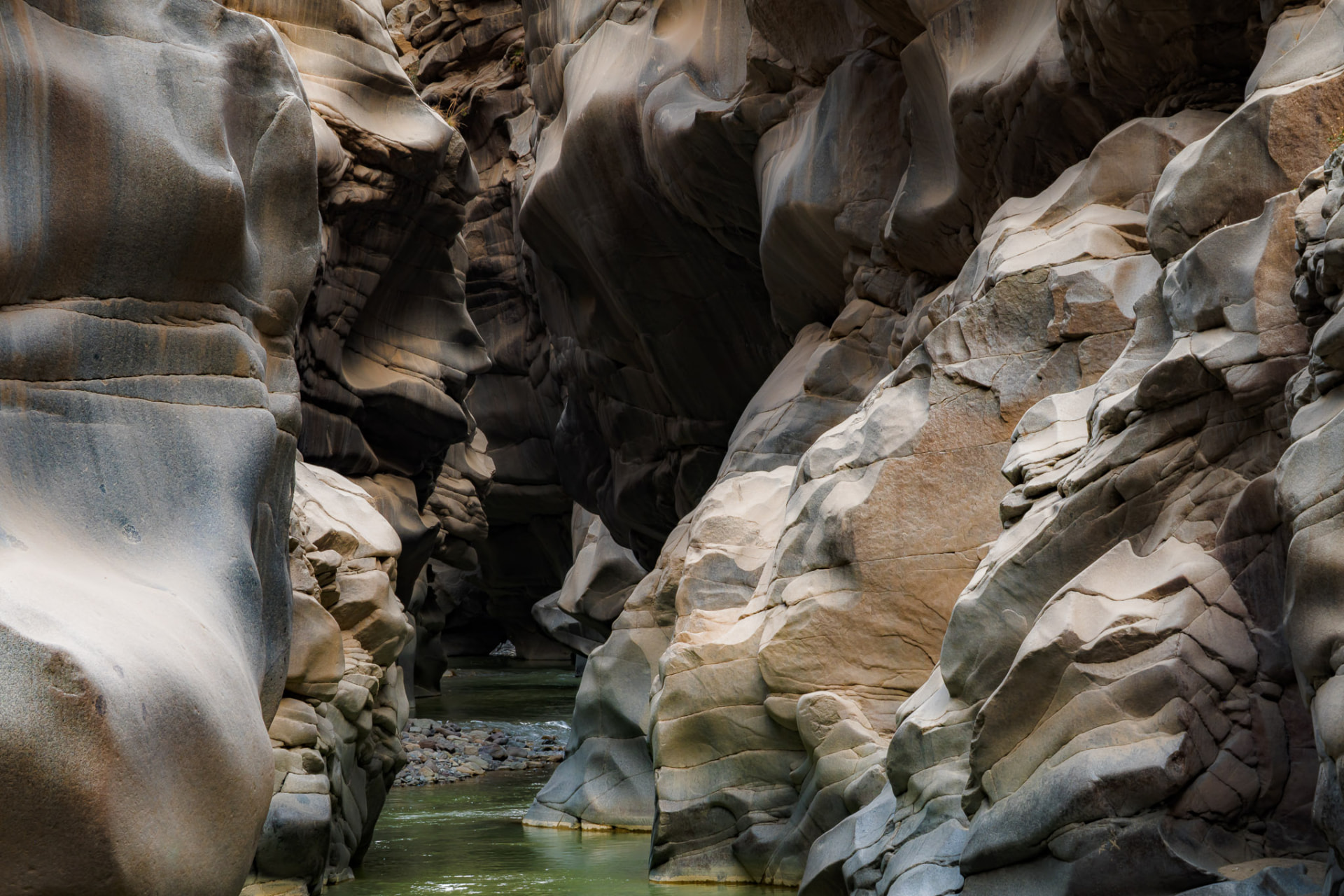Detalle de una pared de granito pulida por el río, con rocas suaves