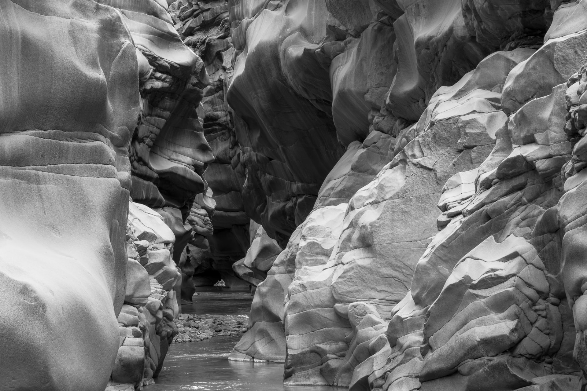 Pared de granito pulida por el río, en blanco y negro, con rocas suaves