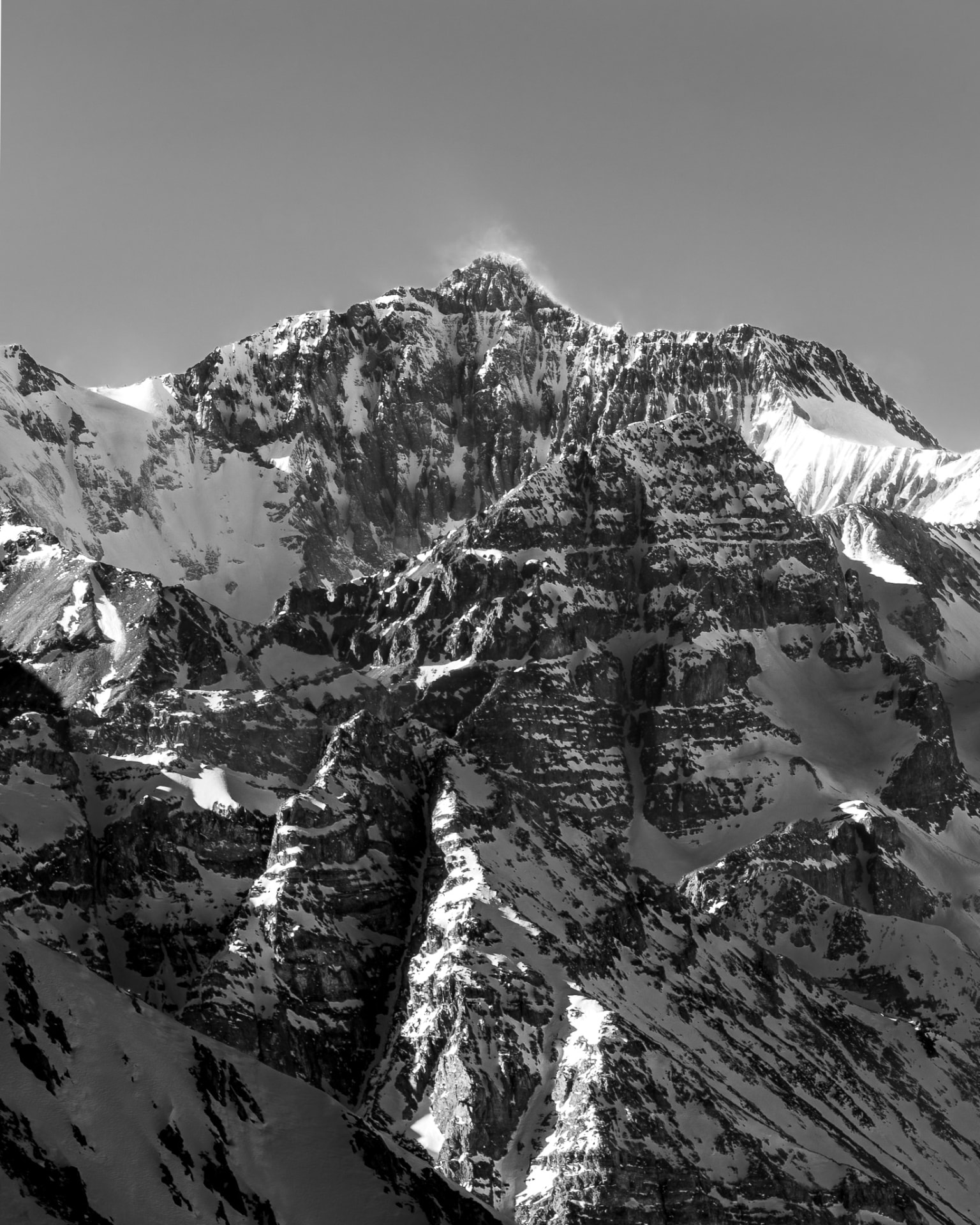 Cara sur del Cerro Altar en blanco y negro, con capas de cordillera y una fina nube levantada por el viento