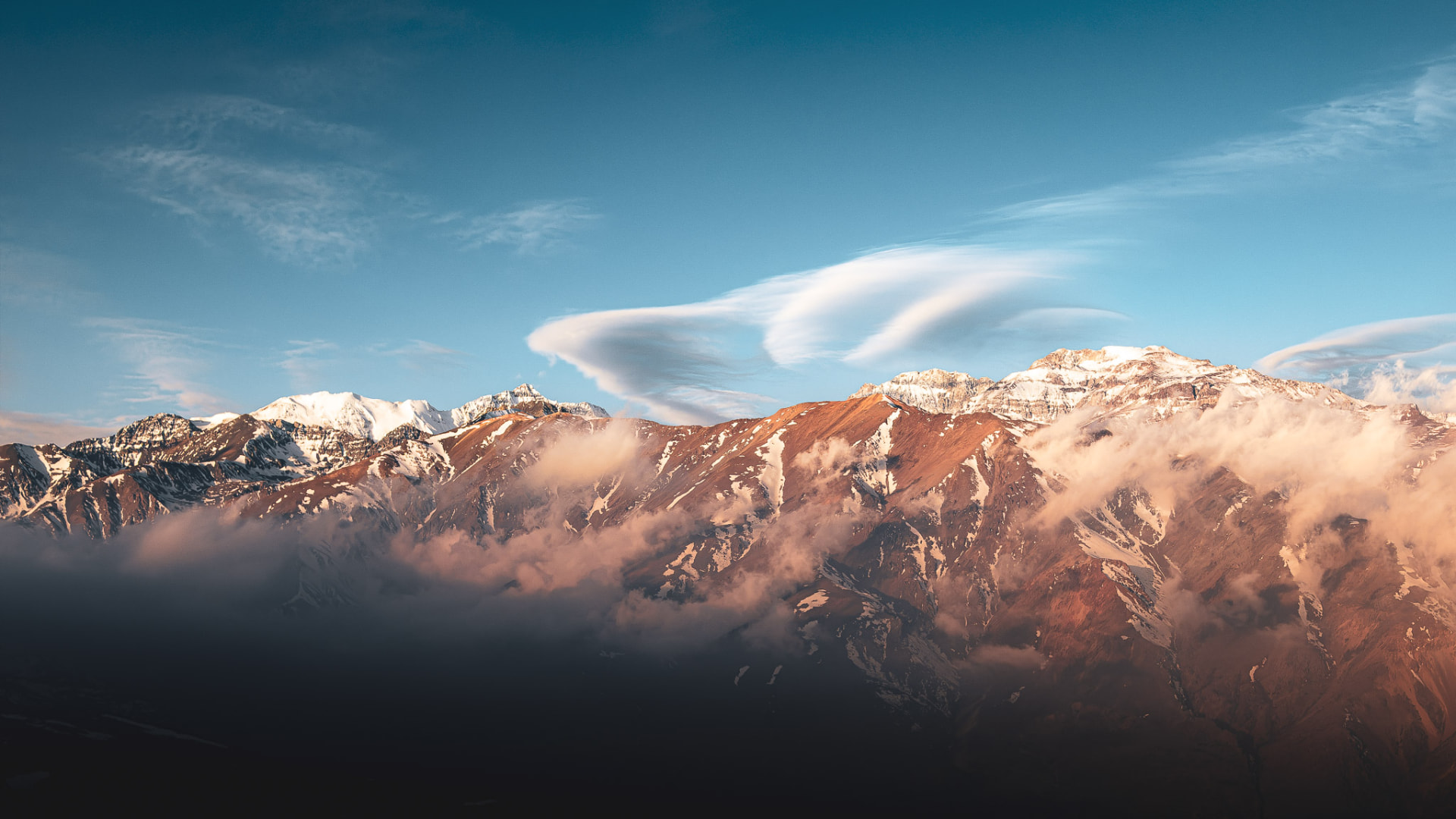 Nubes vistiendo el cordón Yerba Loca, con el Cerro El Plomo detrás